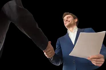 Two business professionals in formal attire shaking hands, one holding paperwork, symbolizing agreement, trust, and the importance of a well-crafted operating agreement for your business.