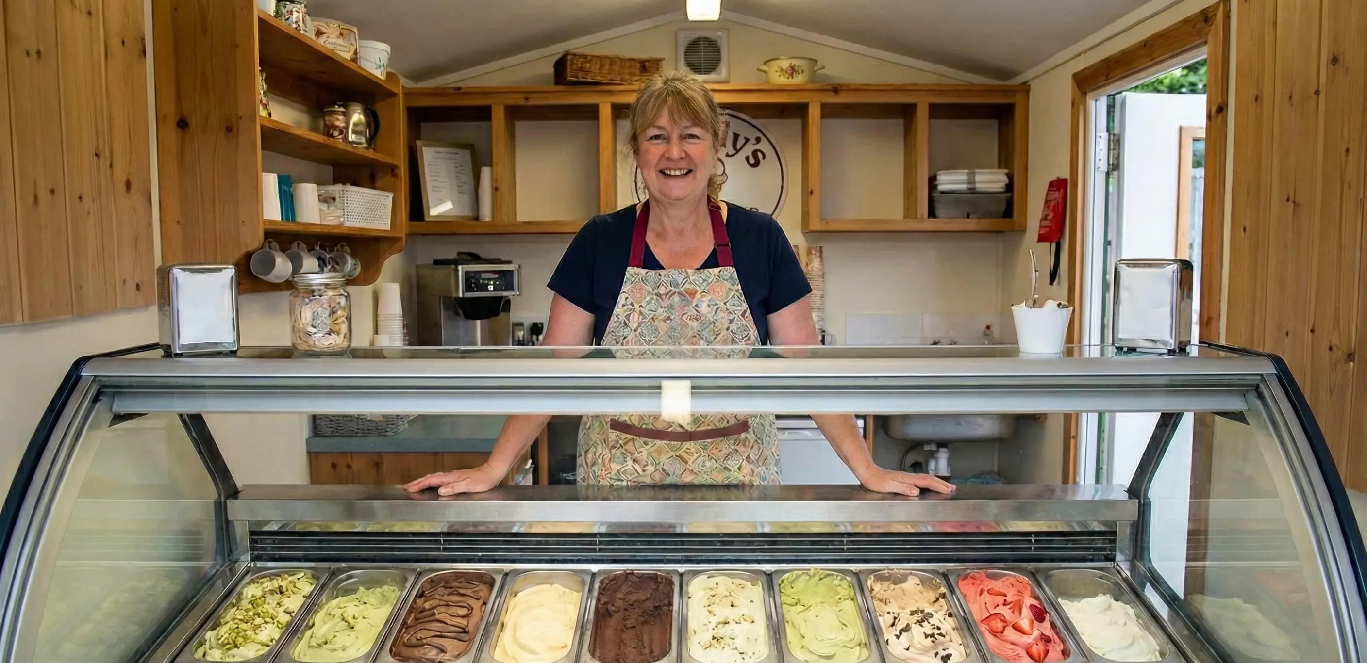 Ice cream shop owner smiling behind her counter, illustrating the branding difference when evaluating a dba vs sole proprietorship for a local business.