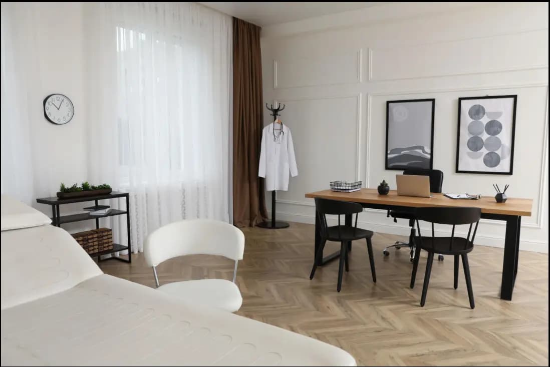 Bright, modern doctor's clinic with an exam table and a desk holding a corporate bylaws template.