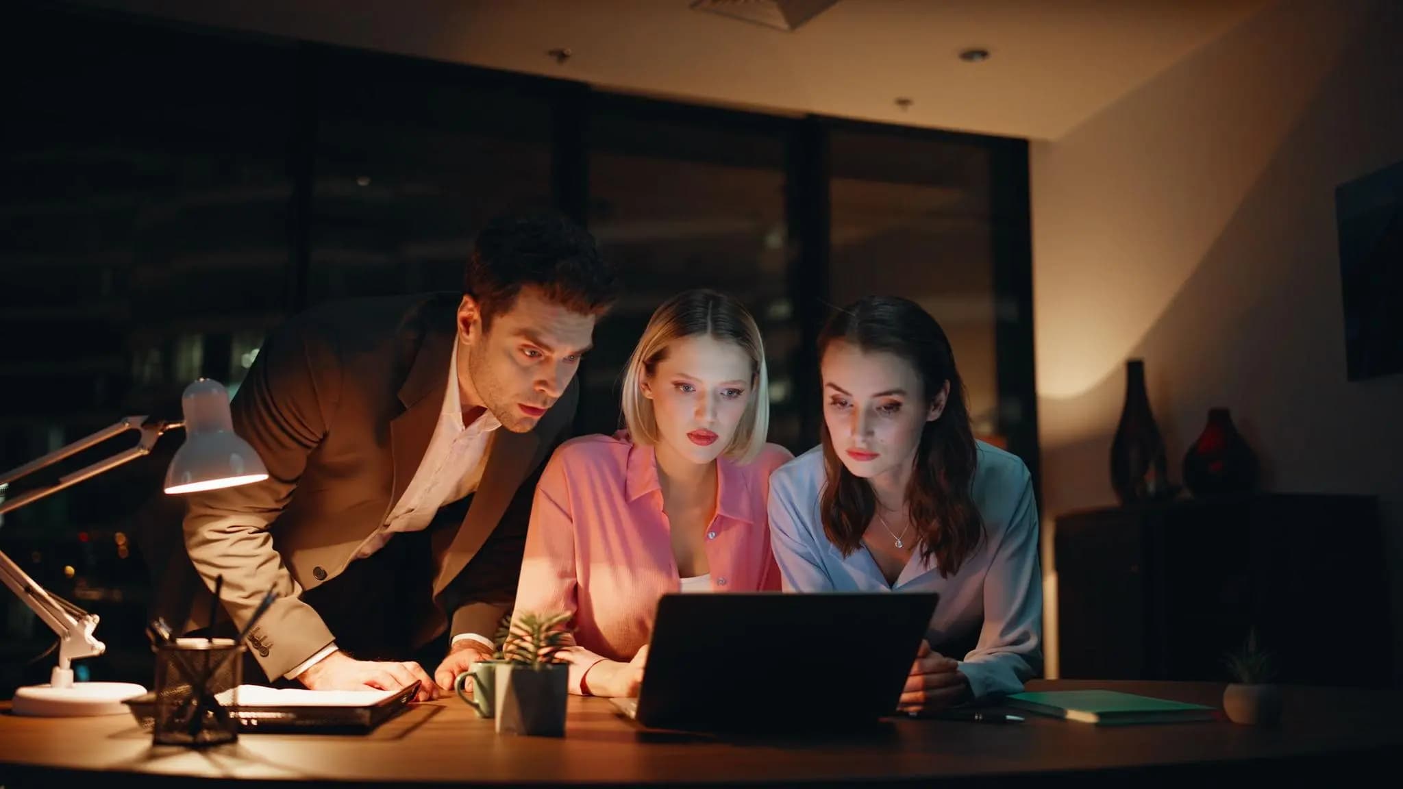 Three e-commerce experts working late at night around a laptop, checking the Florida LLC reinstatement timeline.